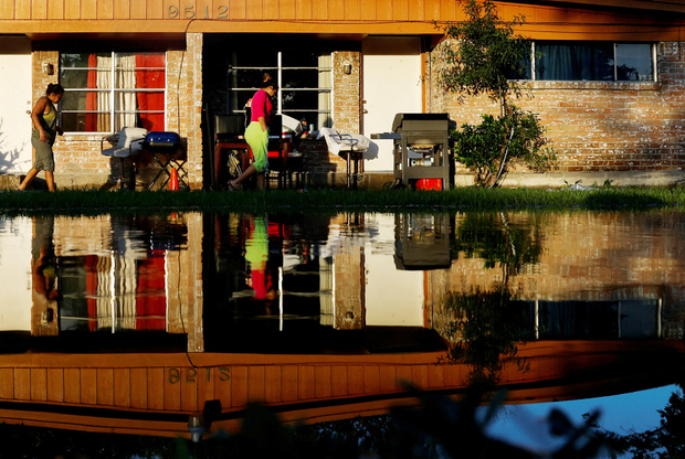 Stanovnici Houstona u Teksasu hodaju uz svoju kuću nakon uragana Beryl (Foto: Daniel Becerril/REUTERS/PIXSELL)